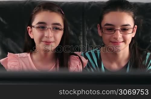 Happy girls with glasses watching tv