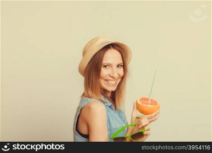 Happy glad woman tourist in straw hat holding sunglasses and grapefruit citrus fruit. Healthy diet food. Summer vacation holidays concept. Instagram filtered.. Happy woman in hat holds sunglasses and grapefruit