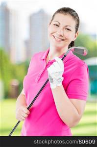 happy golfer on a background of golf courses smiling and holding a golf club