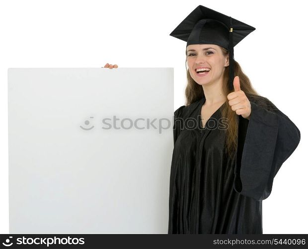 Happy graduation student girl holding blank billboard and showing thumbs up