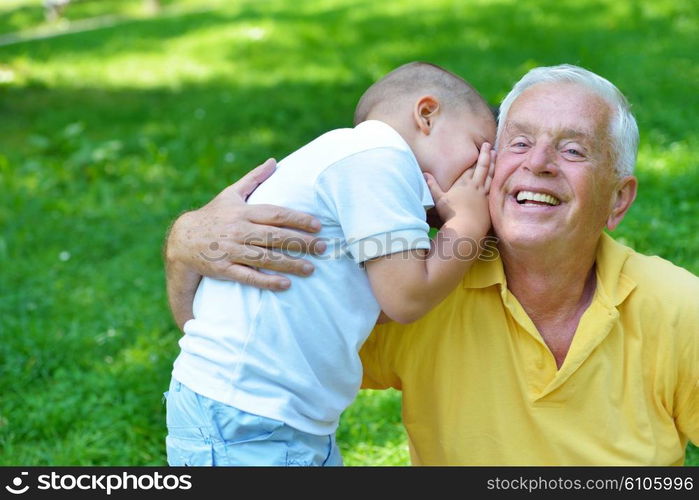 happy grandfather and child have fun and play in park