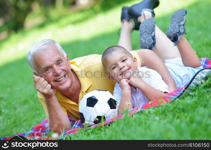 happy grandfather and child have fun and play in park