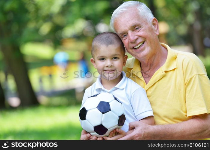 happy grandfather and child have fun and play in park