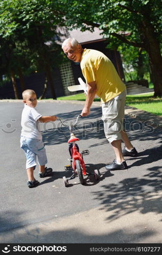 happy grandfather and child have fun and play in park