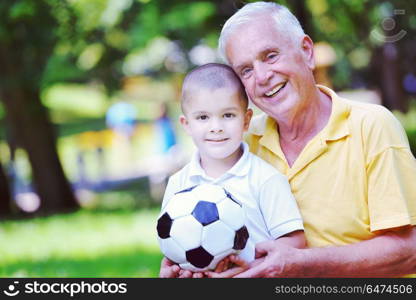 happy grandfather and child have fun and play in park. happy grandfather and child in park