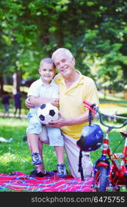 happy grandfather and child have fun and play in park. happy grandfather and child in park