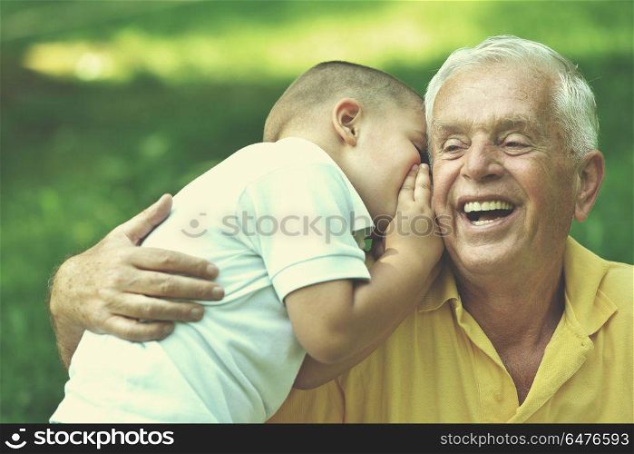 happy grandfather and child have fun and play in park. happy grandfather and child in park