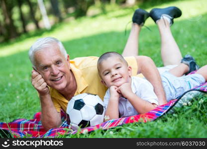 happy grandfather and child have fun and play in park on beautiful sunny day