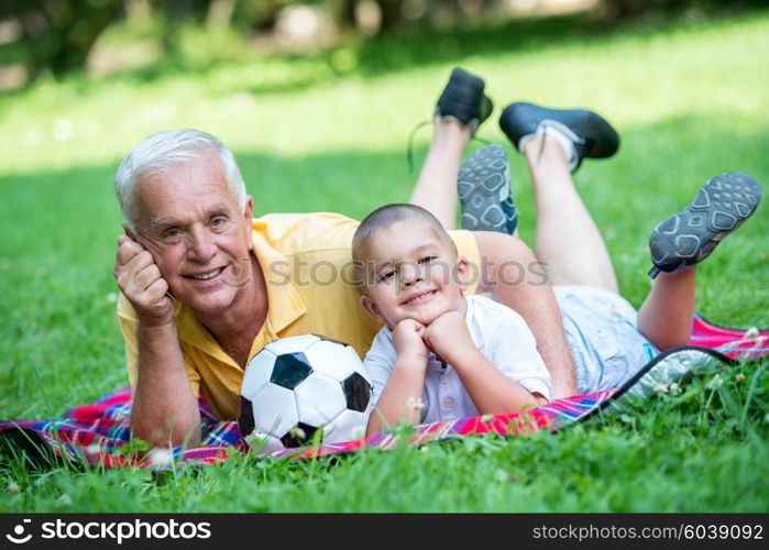 happy grandfather and child have fun and play in park on beautiful sunny day