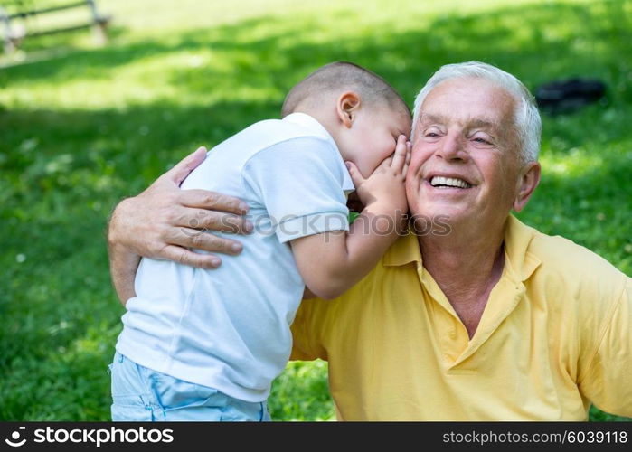 happy grandfather and child have fun and play in park on beautiful sunny day