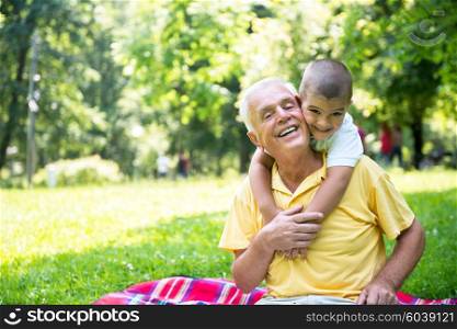 happy grandfather and child have fun and play in park on beautiful sunny day