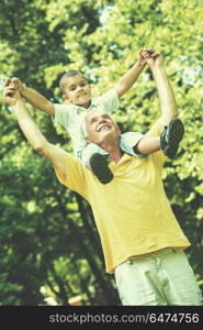 happy grandfather and child have fun and play in park on beautiful sunny day. grandfather and child have fun in park