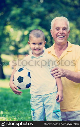 happy grandfather and child have fun and play in park on beautiful sunny day. grandfather and child have fun in park