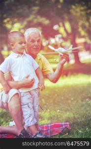 happy grandfather and child have fun and play in park on beautiful sunny day. grandfather and child have fun in park