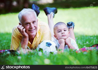 happy grandfather and child have fun and play in park on beautiful sunny day. grandfather and child have fun in park