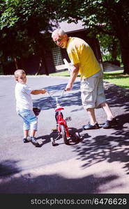 happy grandfather and child have fun and play in park on beautiful sunny day. grandfather and child have fun in park