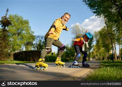 Happy grandfather and grandson on roller skates posing for camera over city park background. Playful weekend time and sports activity concept. Happy grandfather and grandson on roller skates posing for camera