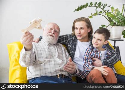 happy grandfather playing with wooden airplane