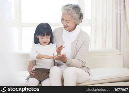 Happy grandma and granddaughter playing games