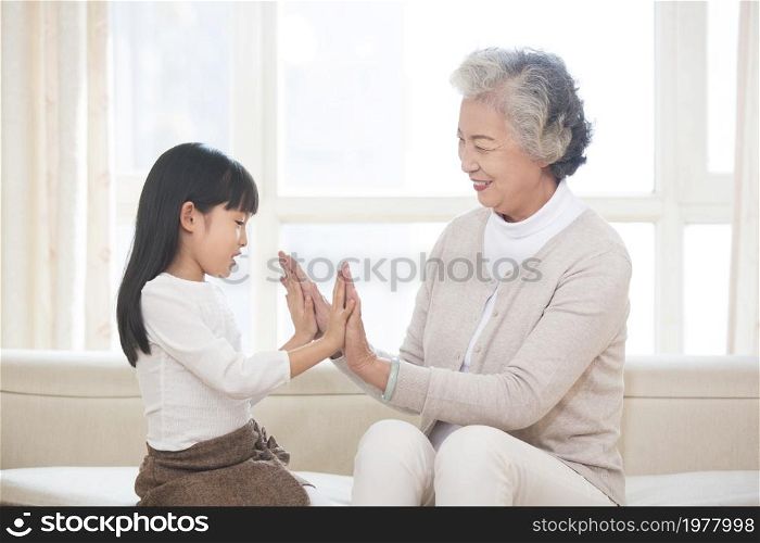 Happy grandma and granddaughter playing games