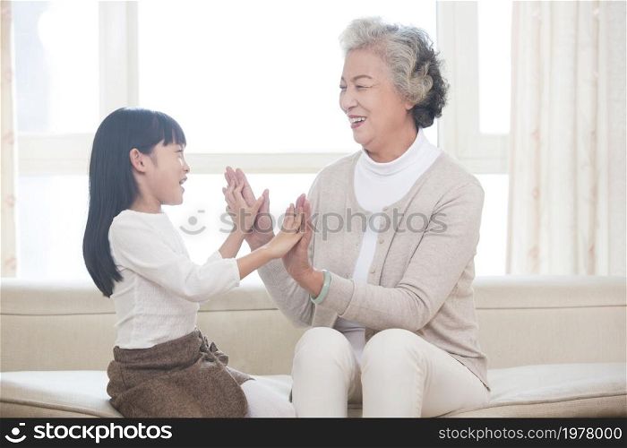 Happy grandma and granddaughter playing games