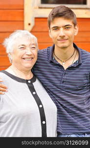 Happy grandmother and grandson in front of house