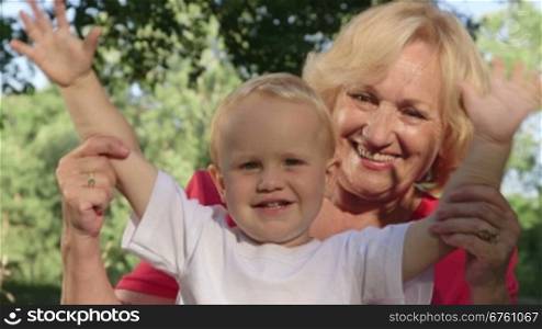 Happy grandmother with her grandchild looking at camera smiling