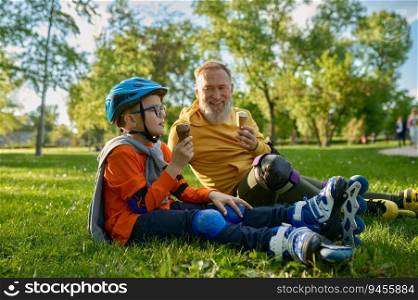 Happy grandpa and grandchild eating ice-cream after roller skating. Happy family rest in park. Happy grandpa and grandchild eating ice-cream after roller skating