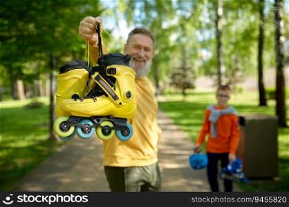 Happy grandparent and grandchild getting ready for extreme riding and active sports pastime in park. Selective focus of roller-skate. Happy grandparent and grandchild in park, selective focus of roller-skate