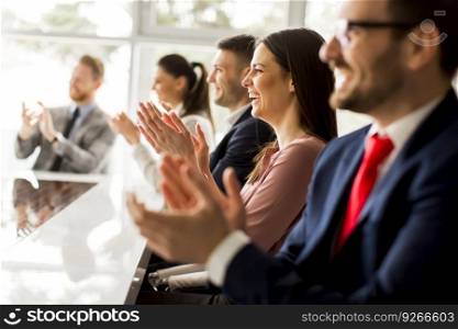 Happy group of businesspeople clapping in office