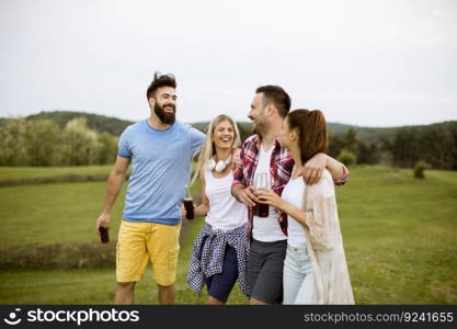 Happy group of friends with drink  having fun and smiling at nature by summer day