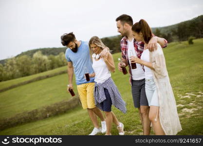 Happy group of friends with drink  having fun and smiling at nature by summer day