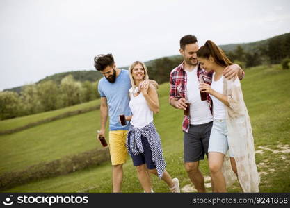 Happy group of friends with drink  having fun and smiling at nature by summer day