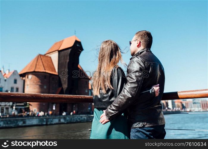happy guy and girl walking along the tourist streets of old Europe in the city of Gdansk