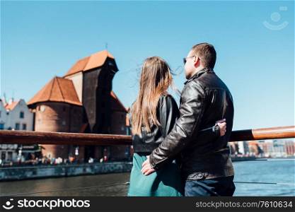 happy guy and girl walking along the tourist streets of old Europe in the city of Gdansk