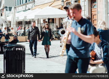 happy guy and girl walking along the tourist streets of old Europe in the city of Gdansk