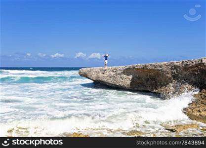 Happy guy on the rocks on Aruba island in the Caribbean