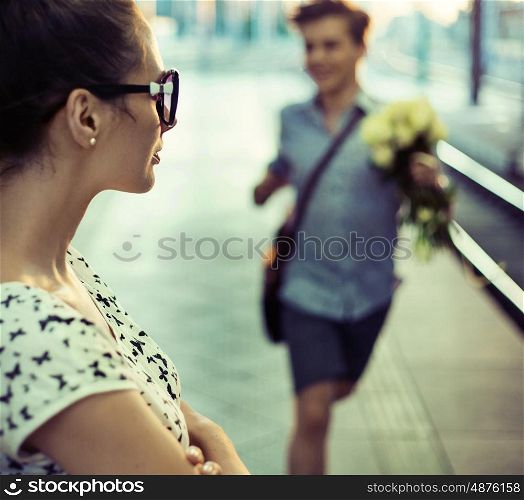 Happy guy trying to give a bouquet of roses to some pretty lady