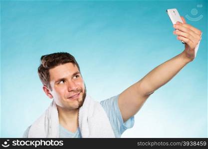 Happy half shaved man taking selfie self photo.. Happy man with half shaved face beard hair taking selfie self photo with smartphone camera. Smiling handsome guy on blue. Skin care and hygiene.
