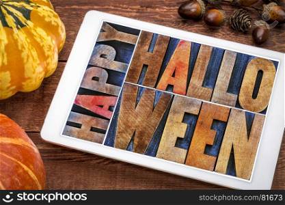 Happy Halloween greeting card - text in vintage grunge wood type printing blocks on a digital tablet with a pumpkin and squash