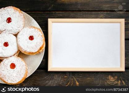 Happy Hanukkah. Empty frame for congratulations text and traditional dessert Sufganiyot on dark wooden background. Celebrating Jewish religious holiday.. Happy Hanukkah. Empty frame for congratulations text and traditional dessert Sufganiyot on dark wooden background. Celebrating Jewish holiday.