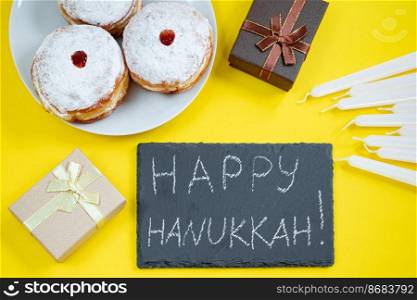 Happy Hanukkah. Jewish dessert Sufganiyot on yellow background. Symbols of religious Judaism holiday. Donuts, candles and gifts.. Happy Hanukkah. Jewish dessert Sufganiyot on yellow background. Symbols of religious Judaism holiday. Donuts, candles and gift.