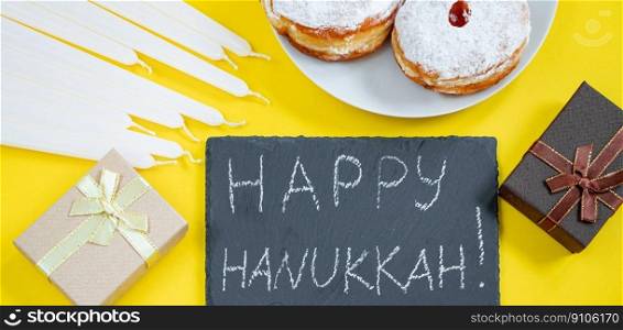 Happy Hanukkah. Jewish dessert Sufganiyot on yellow background. Symbols of religious Judaism holiday. Donuts, candles and gifts. Banner format. Happy Hanukkah. Jewish dessert Sufganiyot on yellow background. Symbols of religious Judaism holiday. Donuts, candles and gift.