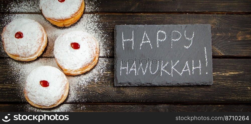 Happy Hanukkah. Traditional dessert Sufganiyot on dark wooden background. Donuts, candles and gifts. Celebrating Jewish religious holiday. Banner format.. Happy Hanukkah. Traditional dessert Sufganiyot on dark wooden background. Donuts, candles and gifts. Celebrating Jewish holiday.