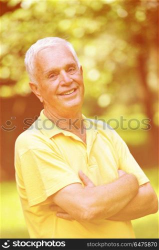 happy healthy and fit elderly man portrait in green background park. elderly man portrait