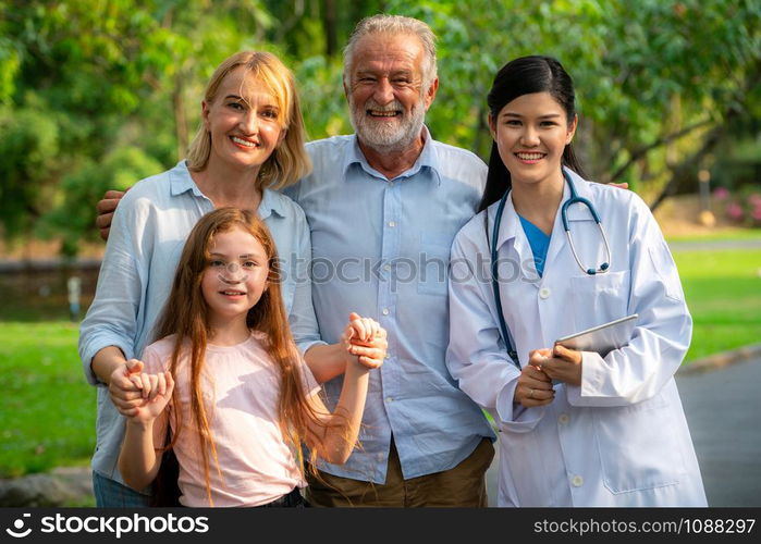 Happy healthy family and doctor talking in the park. People healthcare and medical staff service concept.