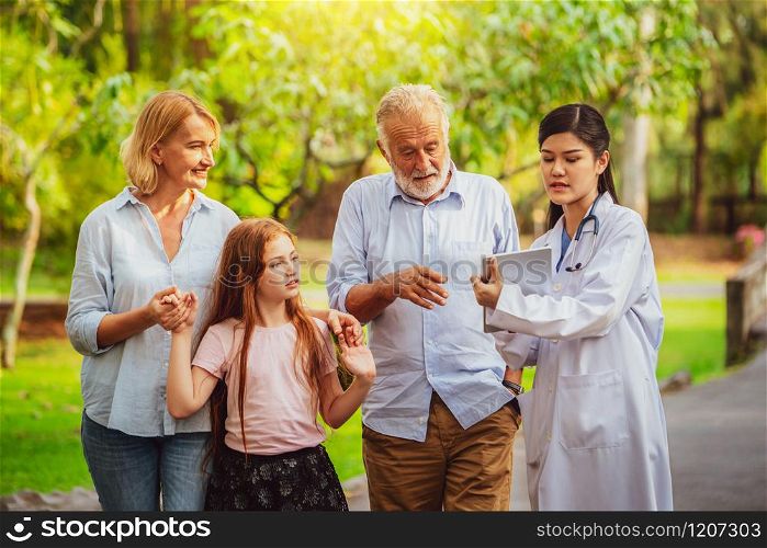 Happy healthy family and doctor talking in the park. People healthcare and medical staff service concept.. Happy healthy family and doctor talking in park.