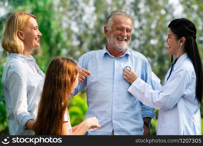 Happy healthy family and doctor talking in the park. People healthcare and medical staff service concept.. Happy healthy family and doctor talking in park.