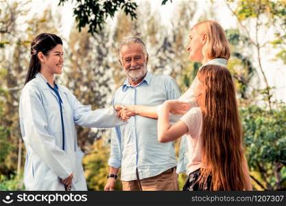 Happy healthy family and doctor talking in the park. People healthcare and medical staff service concept.. Happy healthy family and doctor talking in park.