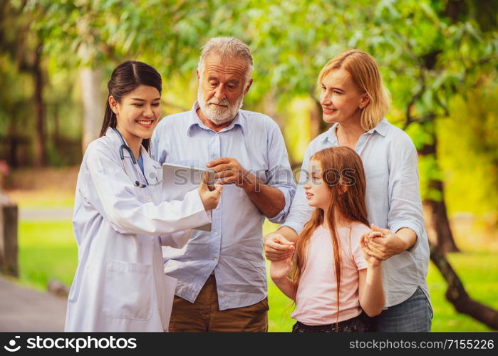 Happy healthy family and doctor talking in the park. People healthcare and medical staff service concept.